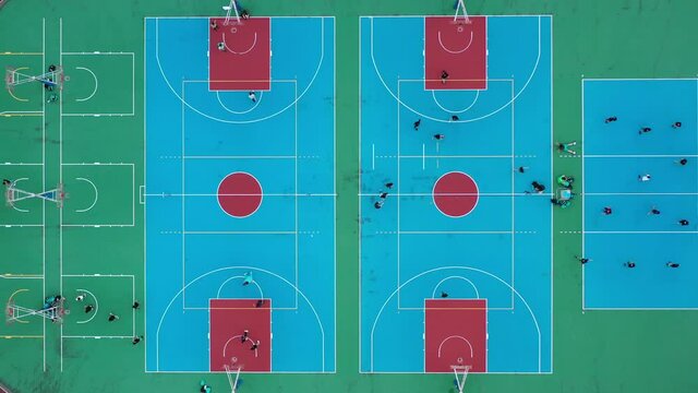 Overhead View Capturing People Playing Basketball In Multipurpose Sports Court, Creative Aerial Shot.