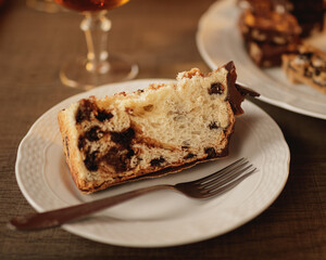 Portion of Christmas Sweet Bread with chocolate, on a white plate with fork. Festivities.