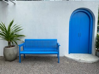 Outdoor Blue bench and blur door with white wall for cafe or hotel style concept