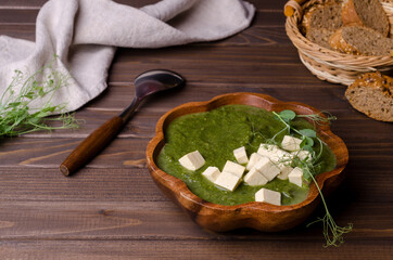 Green cream soup with slices of cheese