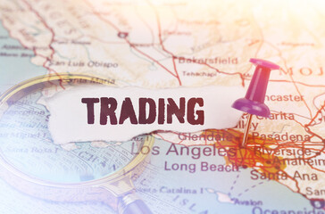 On a map of Los Angeles, next to a magnifying glass and paper with the inscription - trading