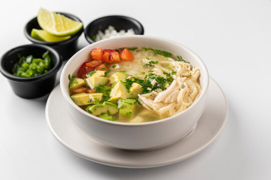 Consome de pollo con jitomate y aguacate
