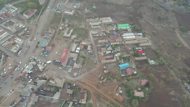 A sunset in a small village of in Kenya. Aerial view following a truck driving through a small town, in rural Africa - top down, drone shot