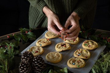 Unrecognizable woman decorating Christmas cookies