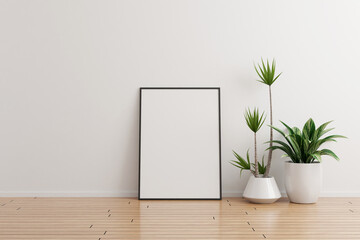 Black vertical photo frame mockup on white wall empty room with plants on a wooden floor