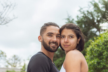 Fototapeta premium A loving couple touching each other looking at the camera outdoors