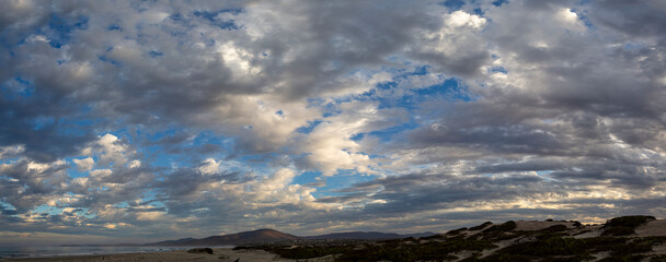 Scattered Morning Clouds Fill Sky Over Ocean Beach 