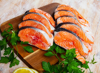 Salmon fillet on cutting board with lemon and parsley. Healthy food