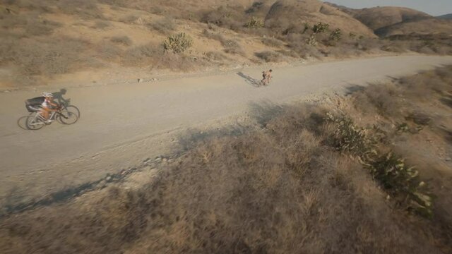 FPV shot weaving through a group of mountain bikers in the desert hills of Mexico.