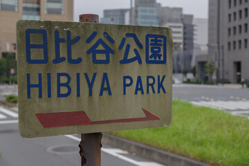日比谷公園を示す標識　日比谷濠の歩道から見える有楽町、丸の内の風景