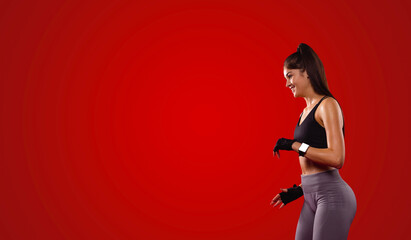 Fototapeta na wymiar The side view photo of a smiling glory girl having beautiful slim body wearing sports clothes comfortable for fitness exercises and with digital watch on her hand.