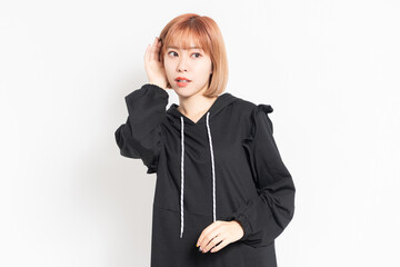 聞き耳を立てて噂話を聞く若い女性