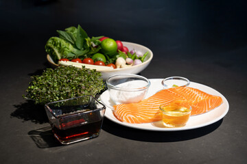 Ingredients of Spicy Raw Salmon are prepared on granite top table such as lemonglass tomato lemon garlic chilli salt oil and wasabi on dishes.