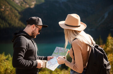 Young tourist couple, man and woman, on hiking path in mountains