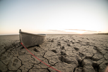 boat at the bottom of the dried up sea traces around