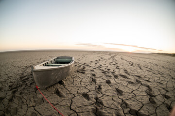 boat at the bottom of the dried up sea traces around