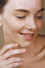 Young smiling woman with perfect freckled skin and nude makeup