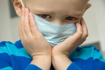 Selective focus. Kid using the medical face mask . Protection against corona virus. Sick child...