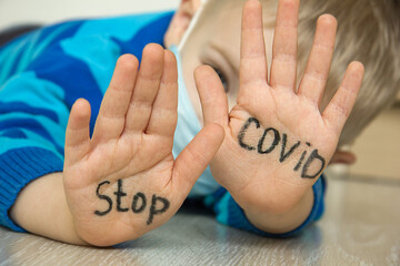 Young ill boy at the hospital wants to stop proliferation of coronovirus. Kid using the medical...