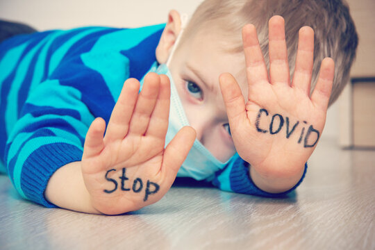 Young Ill Boy At The Hospital Wants To Stop Proliferation Of Coronovirus. Kid Using The Medical Face Mask For Protection. Sick Child Breathes Through A Protective Mask