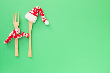  The creative concept of a festive menu mockup, diet, natural healthy food on green background. Wooden cutlery. Background for christmas,New Year lunch, dinner invitation or party with copy space