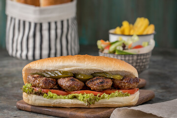 meatball sandwich and 
fried potatoes on the 
wood plate 