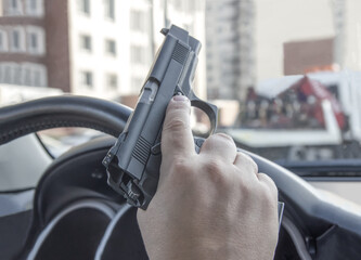 Man driving a car with a weapon, gun in his hand. The criminal steals the car. Danger district of...