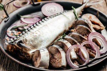 Marinated mackerel fillet with sliced onion served on a metal tray. Food recipe background. Close up