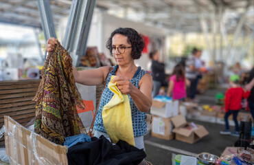 woman choosing clothes at garage sale