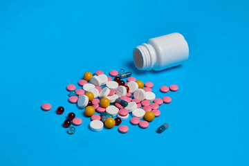 multicolored pills Pharmaceuticals medicines syringe blue background