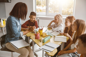 Young teacher during the lesson with pupils in the classroom