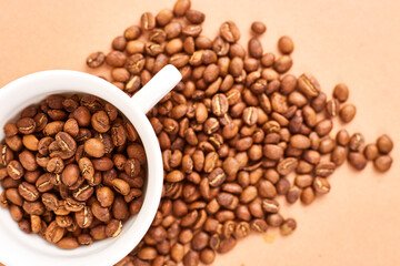 Coffee beans in coffee cup on pastel background. Space fot text