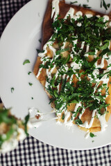 Pancakes with cheese on a plate in a restaurant. Breakfast at the cafe. A woman eats pancakes for breakfast from disposable dishes. Top view and vertical photo