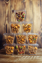 Close-up of a beer snack. Hazelnuts, cashews and peanuts with different flavors in transparent packaging. Snacks go with alcohol. Takeaway food. Concept