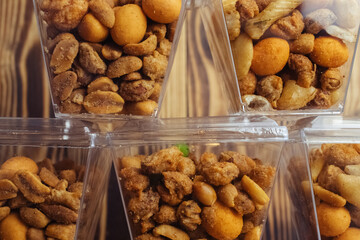 Close-up of a beer snack. Hazelnuts, cashews and peanuts with different flavors in transparent packaging. Snacks go with alcohol. Takeaway food. Concept