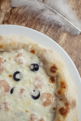 Close-up of pizza with shrimps. Seafood and vegetarian food. Italian food in restaurants and cafes. The concept of marine ingredients in meal preparation.