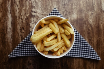 Top view of French fries. Fry dip. The concept of fast food, quick bites and restaurants for catering. Potatoes in carton and ketchup. Vertical photo.