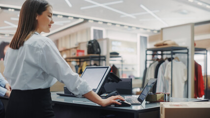 Clothing Store: Businesswoman and Visual Merchandising Specialist Uses Laptop To Create Stylish...