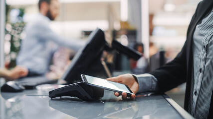 Clothing Store: Woman At Counter Buys Clothes Paying with Smartphone Through, Contactless NFC...