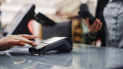 Clothing Store: Woman At Counter Buys Clothes Paying with Smartphone Through, Contactless NFC...
