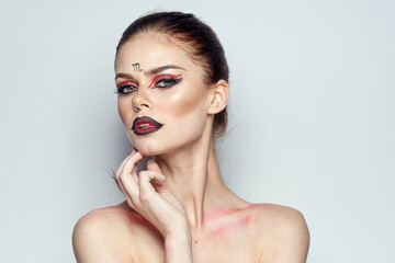 Naklejka premium attractive woman posing scorpio sign on forehead cosmetics light background