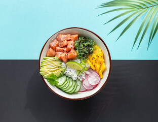 Delicious poke bowl with rice, mango, avocado, radish, chukka salad, cucumber, and marinated fresh...