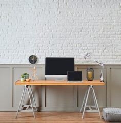 Modern working desk and wooden table design, computer and laptop style, home accessory, lamp and chair decor. White brick and brown classic wall background.