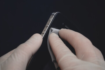 Smartphone repair. The phone is in the hands of a master in gloves