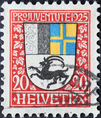 Obraz premium Switzerland - Circa 1925: a postage stamp printed in the Switzerland showing a coat of arms with ibex of the Swiss canton of Grisons on a charity postal stamp