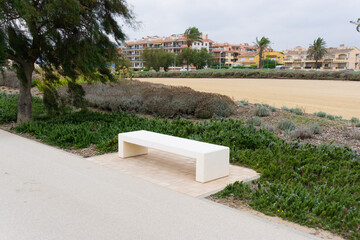 Image of a white stone bench on a walk