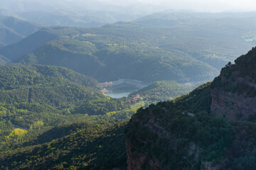 Fototapeta premium View of a lake between mountains with sunset mist