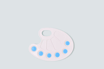Watercolor palette on a blue pastel background. Artistic concept with copyspace.