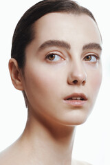 Closeup portrait of beautiful girl with clean shiny healthy skin and nude makeup. Natural skincare beauty.