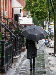 Woman walking with umbrella in the rain in Brooklyn. High quality photo